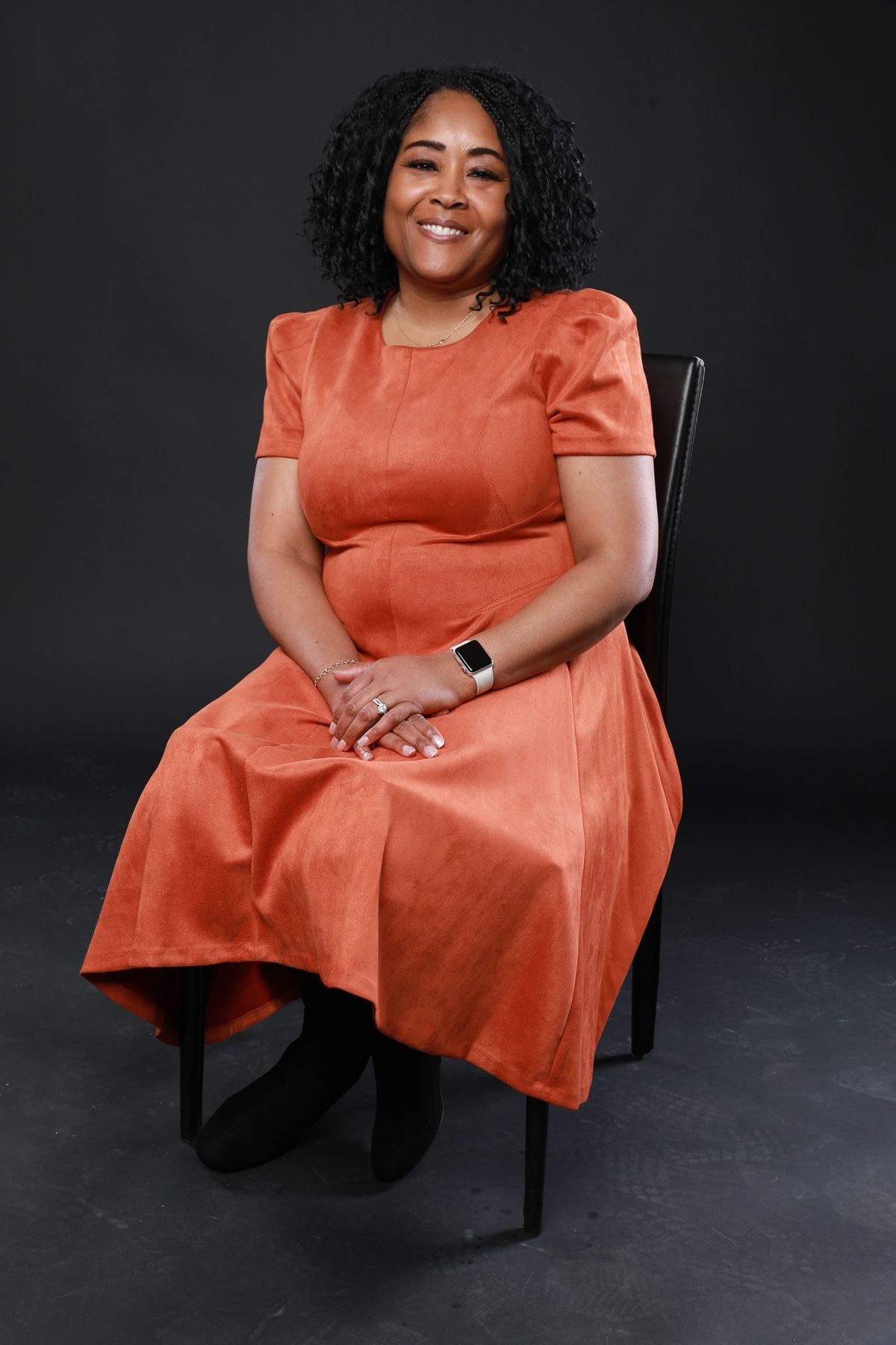 Lakisha Shepard seated in a rust dress